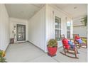 Inviting front porch with rocking chairs, creating a relaxing atmosphere at 506 Tranquil Waters Way, Summerville, SC 29486