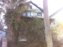Older home with overgrown vegetation, needing significant exterior repairs at 5 President Pl, Charleston, SC 29403