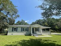 Charming ranch home with a covered porch and well-maintained lawn at 902 Poplar St, Walterboro, SC 29488