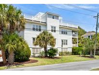 Three-story white beach house with palm trees at 7 33Rd Ave, Isle of Palms, SC 29451