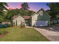 Charming one-story home with a two-car garage and manicured lawn at 520 Woodland Shores Rd, Charleston, SC 29412