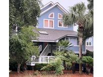 Two-story light blue house with white trim and a deck at 2221 Oyster Catcher Ct, Seabrook Island, SC 29455