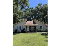 Cute yellow house with blue shutters and a well-maintained lawn at 106 Teddy Ct, Summerville, SC 29485