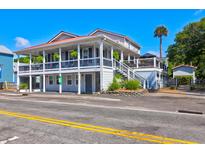 Two-story home with a wrap-around porch and fenced backyard at 118 E Ashley And 110 E Cooper Ave Ave, Folly Beach, SC 29439