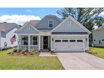 One-story home with light gray siding, white trim, and a two-car garage at 2033 Kings River Trail, Hollywood, SC 29449