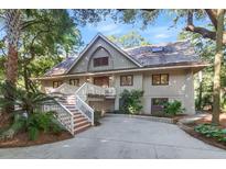A charming two-story home with a large front porch and a lush green lawn at 202 Needlerush Rd, Kiawah Island, SC 29455