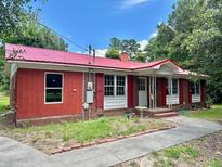 Brick ranch house with red metal roof, shutters, and a paved walkway at 2042 Sniders Highway, Walterboro, SC 29488
