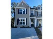 Two-story tan house with dark trim, driveway, and landscaping at 495 Green Fern Dr, Summerville, SC 29483