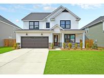 Two story farmhouse style home with white siding and dark accents at 537 Rendezvous Way, Huger, SC 29450
