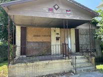 A neglected house with boarded-up windows and doors at 17 Reid St, Charleston, SC 29403