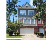 Two-story townhome with gray and red siding, two-car garage, and landscaping at 9120 Parlor Dr, Ladson, SC 29456