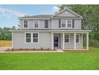 Two-story gray house with a front porch, black shutters, and a well-manicured lawn at 116 Braxton Rd, Harleyville, SC 29448