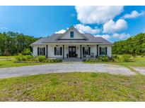 White farmhouse with black accents and a metal roof at 151 Farmers Ln, Moncks Corner, SC 29461