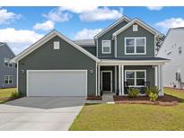 Two story green house with rocking chairs on the porch at 4413 Palm Shadow Dr, Summerville, SC 29485