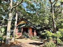 Quaint cottage nestled amongst lush greenery, offering curb appeal at 3902 Hartnett Blvd, Isle of Palms, SC 29451