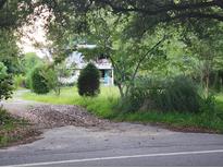 A damaged house exterior with overgrown yard at 1132 Brownswood Rd, Johns Island, SC 29455