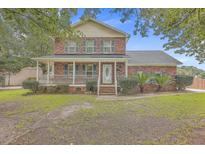 Brick two-story house with front porch and landscaped yard at 5399 Indigo Fields Blvd, Charleston, SC 29418