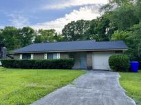 Brick ranch home with a two-car garage and well-manicured lawn at 1039 Yorktown Dr, Charleston, SC 29412