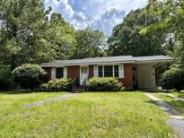 Brick ranch home with a covered carport and well-maintained lawn at 2751 Mawood Ave, North Charleston, SC 29406