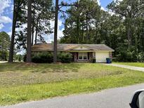 Ranch style home with mature trees and well-maintained yard at 4493 Outwood Dr, Ladson, SC 29456