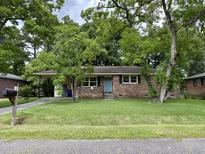 Brick ranch house with a spacious lawn and mature trees at 5308 Albert St, North Charleston, SC 29418