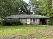 Brick ranch house with carport and mature landscaping at 6224 Bevington Rd, Hollywood, SC 29449