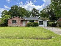 Brick ranch home with carport and spacious lawn at 7070 N Kenwood Dr, North Charleston, SC 29406