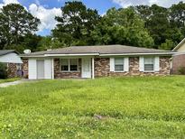 Brick ranch home with a large grassy yard at 7608 Crossgate Blvd, North Charleston, SC 29420