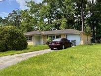 Ranch-style home with a carport and well-maintained lawn at 7752 Cherrywood Dr, North Charleston, SC 29418