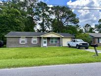 Brick ranch house with a spacious yard and attached garage at 9880 Berrywood Dr, Ladson, SC 29456