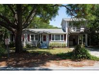 Two-story home with a tree-lined yard and elevated deck at 1302 E Ashley Ave, Folly Beach, SC 29439