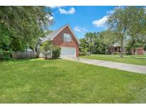 Brick home with a spacious yard and attached garage at 8300 Berringer Bluff Dr, Charleston, SC 29418
