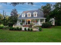 Two-story home with wrap-around porch and fountain at 6949 Maybank Hwy, Wadmalaw Island, SC 29487