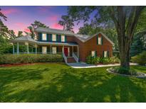 Brick house with large front yard, porch and mature trees at 181 Pekoe Ct, Summerville, SC 29483