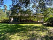 Brick ranch house with a large front porch and yard at 1229 Central Ave, Summerville, SC 29483