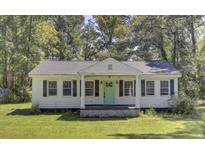 Charming white cottage with a light green door and black shutters at 1586 Highway 15, Saint George, SC 29477