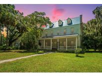 Historic home with wrap-around porch and lush landscaping at 8083 Point Of Pines Rd, Edisto Island, SC 29438