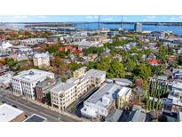 Aerial view of a city neighborhood with lush green spaces and water views at 284 Meeting St # 203, Charleston, SC 29401