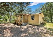 Yellow single-wide mobile home with front porch and large yard at 137 Thelma Dr, Summerville, SC 29485