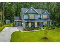 Two-story house with gray siding, stone accents, and a large yard at 3000 Flat Rock Ln, Ridgeville, SC 29472