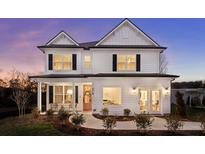 Two story white farmhouse style home with black shutters and a welcoming front porch at 416 Grove End Rd, Moncks Corner, SC 29461