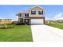 Two story home with a two-car garage, landscaping, and a large driveway at 218 Rhodes Ct, Summerville, SC 29486