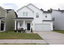 Charming two-story white house with a gray roof and attached garage at 217 Pink Azalea St, Summerville, SC 29485