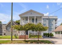 Two-story white house with a front porch and landscaping at 404 Sumter St, Charleston, SC 29403