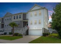 Two-story townhome with attached garage and American flag at 210 Winding River Dr, Johns Island, SC 29455