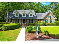 Brick home with green shutters and landscaped yard at 10 Trail Hollow Dr, Charleston, SC 29414