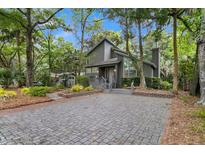 Gray house exterior with brick paver driveway and landscaping at 589 Oyster Rake Dr, Kiawah Island, SC 29455