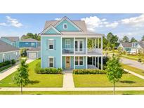 Two-story light blue house with front porch and landscaping at 112 Archdale St St, Summerville, SC 29486