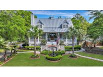 Two-story home with metal roof, porch, and fountain at 705 S Magnolia St, Summerville, SC 29483