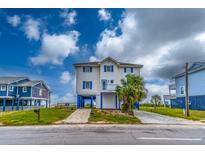 Two-story beach home with blue accents and elevated foundation at 144 Palmetto Blvd, Edisto Island, SC 29438